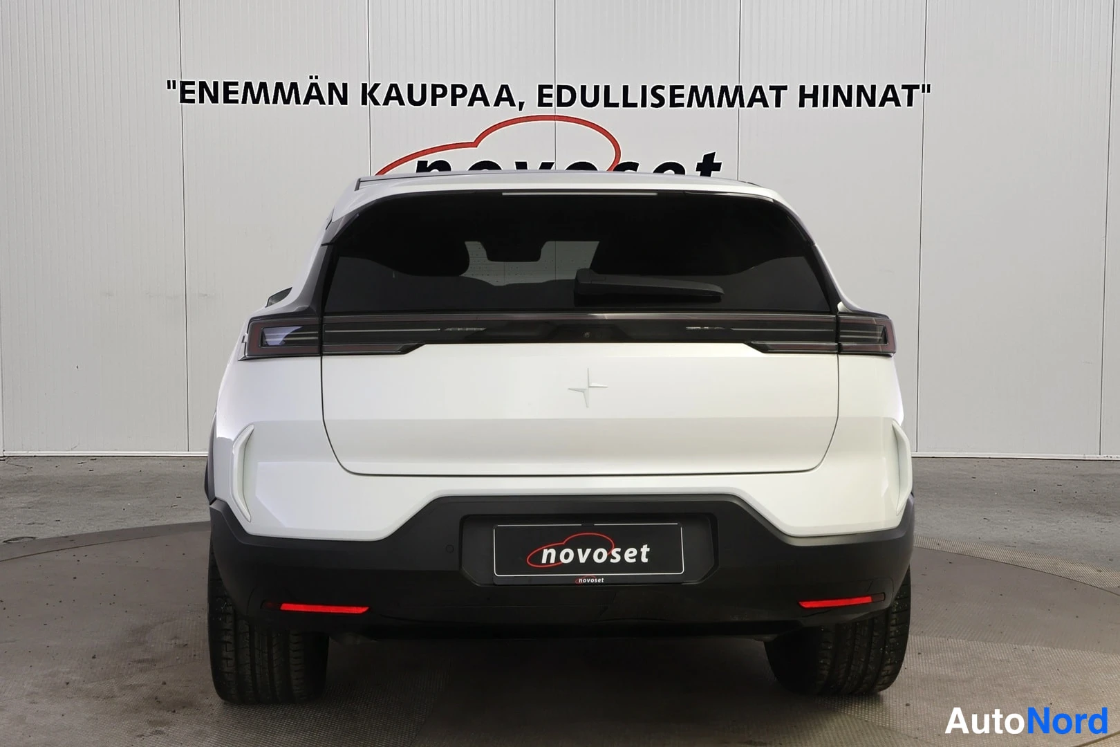 Takaa: Valkoisen Polestar 3 -maasturin takaosa suoraan takaa kuvattuna sisätiloissa.