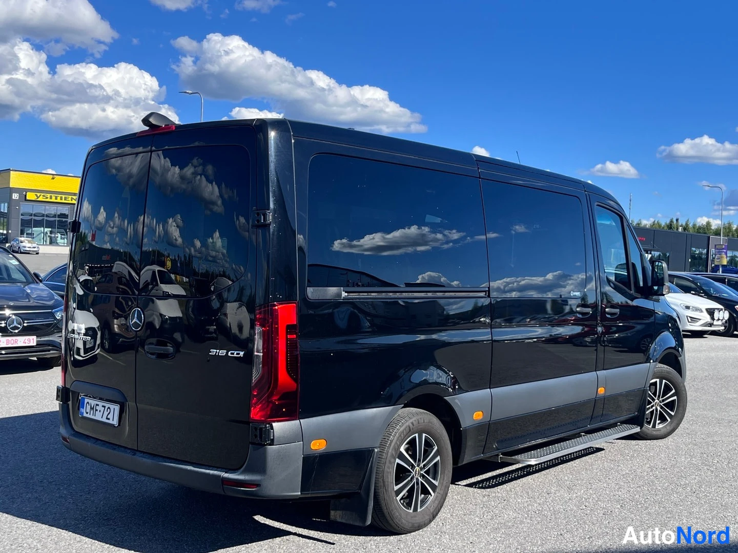 Takaviisto: Musta Mercedes-Benz Sprinter takaviistöstä vasemmalta; peräovessa 316 CDI -teksti ja tarrat.