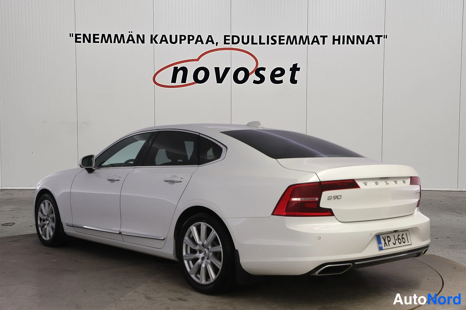 Takaviisto: Valkoisen Volvo S90:n takaosa ja vasen sivu kolmivartalokuvassa oikealta, rekisterikilpi.