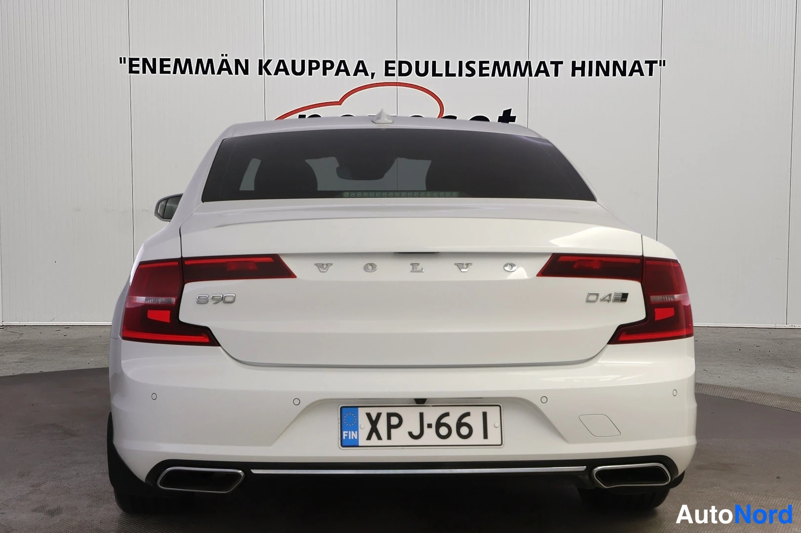 Takaa: Valkoisen Volvo S90 D4:n takaa päin kuvattu perä, VOLVO- ja S90/D4-merkinnät, rekisterikilpi.