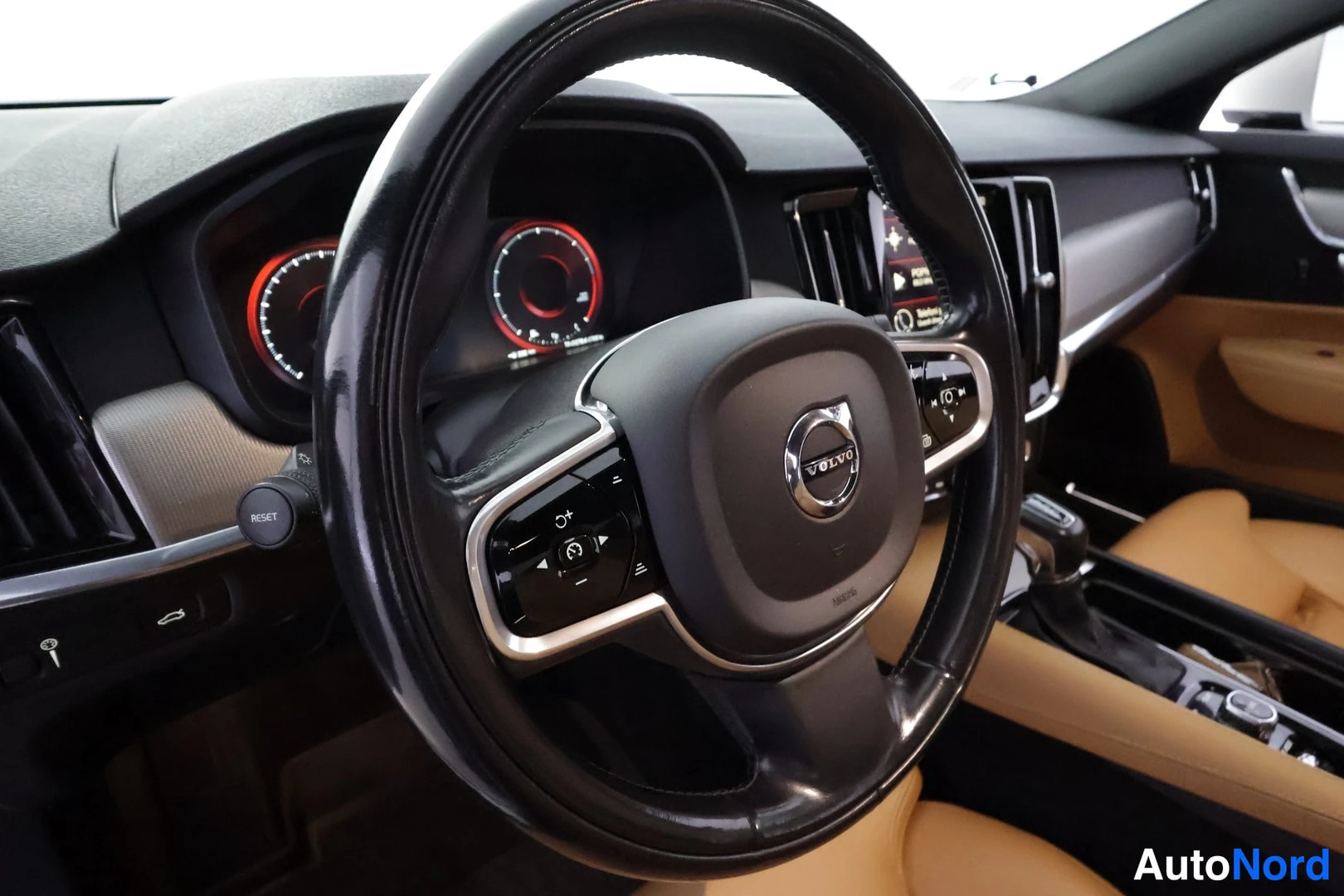 Muu: Volvo-ohjauspyörä ja mittaristo punaisilla mittaritaustauksilla, tumma kojelauta ja keskinäyttö.