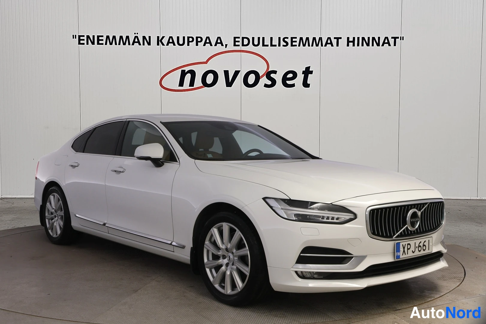 Etuviisto, nokka oikealle: Valkoinen sedan autonäytöksessä, etukulmakuva oikealta; keulagrilin ja valojen sekä eteläpään profiili näkyvissä, rekisteri.