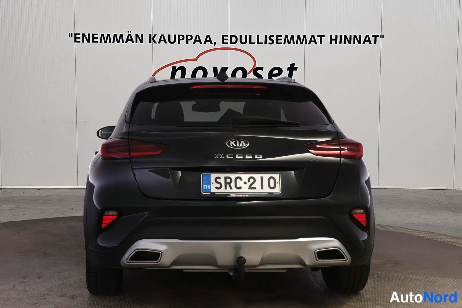 Takaa: Kia XCeed, musta farmuri suoraan takaa kuvattuna, valkoinen novoset-tausta.