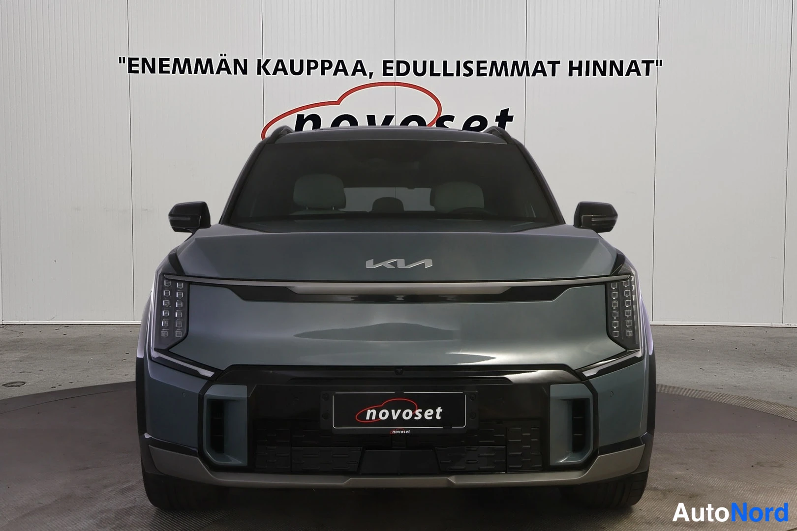 Edestä: Kia EV9 suoraan edestä kuvattuna; ohut ylä-äänvalojuova, pystysuorat päiväajovalot ja musta etupaneeli.