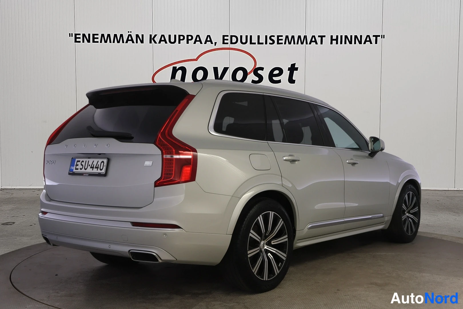 Takaviisto: Volvo XC90:n takaosa ja oikea kylki kolmen neljäsosan kulmasta, vaalean beigeporuinen akseli, rekisterikilpi.