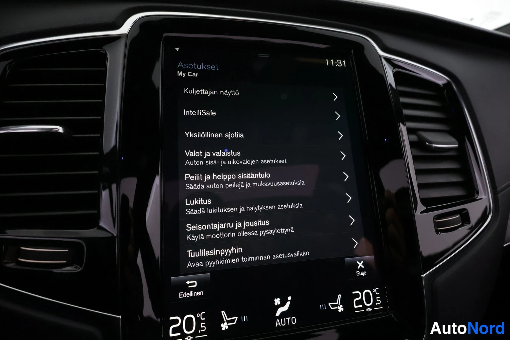 Yksityiskohta: Auton kojelaudan keskinäyttö, jossa on auki Asetukset-valikko (My Car) valikoinein kuten Valot ja valaistus ja Lukitus, alareunassa lämpötilat 20 °C ja AUTO-mer