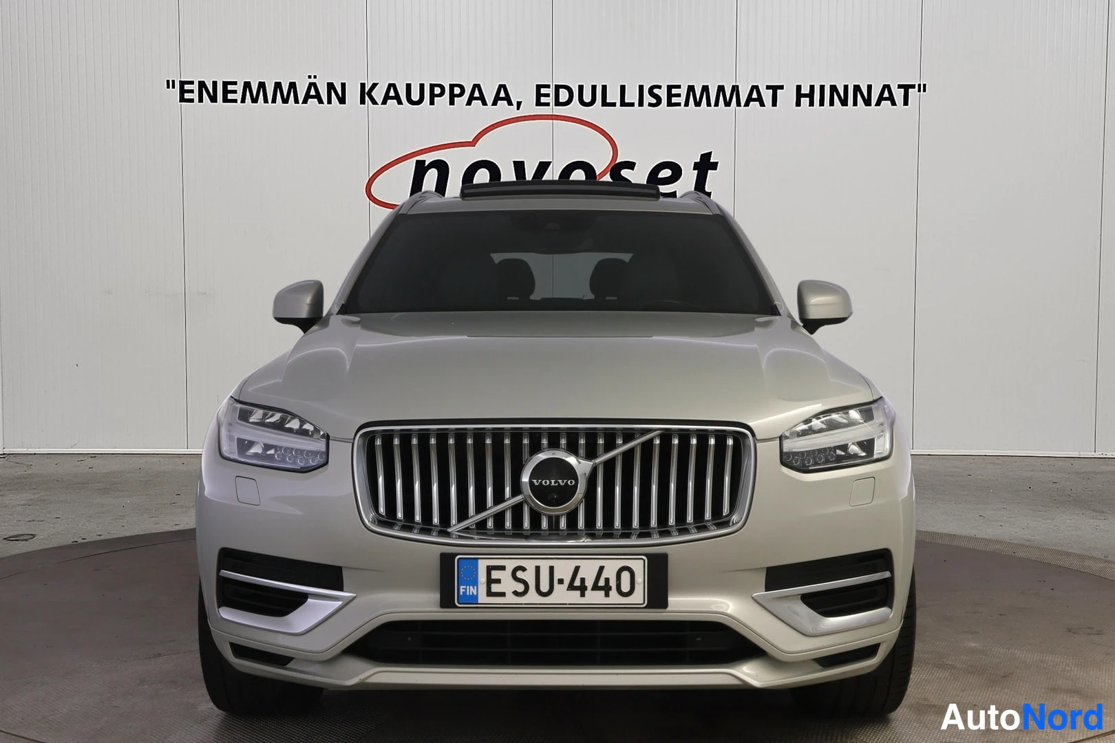 Edestä: Volvo XC90 suoraan edestä kuvattuna: pystysäleikköinen etusäleikkö Volvo-merkillä, ajovalot, panoraamakatto ja rekisteri.