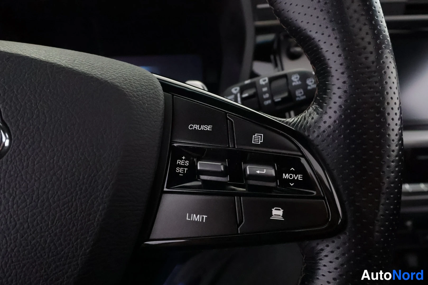 Yksityiskohta: Lähikuva ohjauspilarin oikealla puolella sijaitsevasta valitsimesta (cruise control). Valitsimessa on painikkeet CRUISE, LIMIT ja MOVE sekä kytkimet RES-SET.