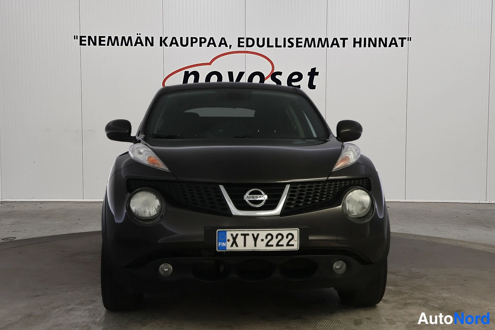 Edestä: Nissan Juke etunäkymä, tummanharmaa kori, rekisterikilpi, Nissan-merkki keulassa
