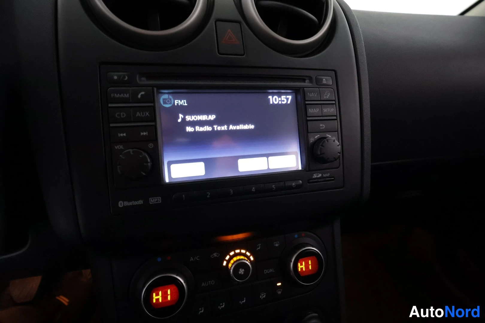 Muu: Ristiinnaviointia: auton kojelaudan radionäyttö näyttää FM1-kanavan ja tekstin SUOMIRAP / No Radio Text Available, kellonaika 10:57. Alla AUTOMATIC CLIMATE -pai