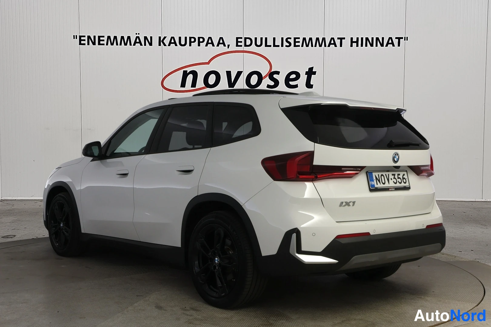Takaviisto: Valkoinen BMW iX1 takakolmasosanäkymä, takaluukussa iX1-tunnus, rekisteritunnus.