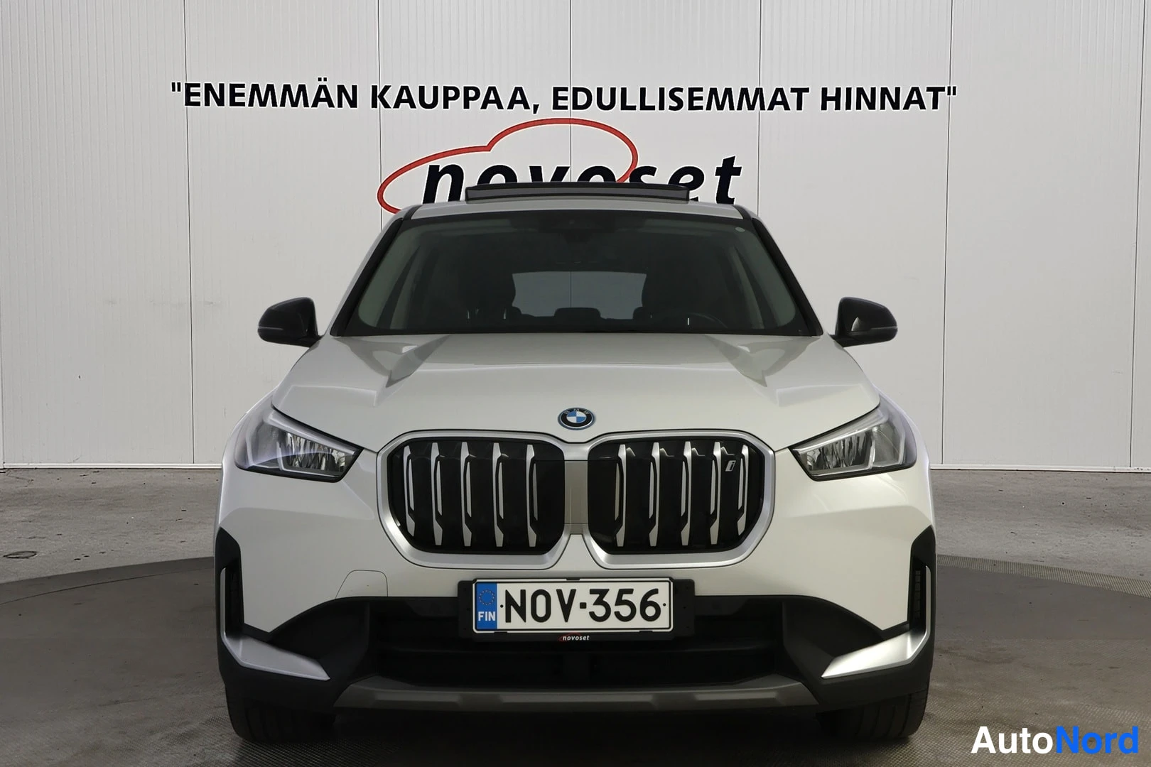 Edestä: Etukuvat valkoista BMW-autoa. Grilli, etupuskuri ja suoraan edessä olevat katsojalle osoitetut LED-valot.