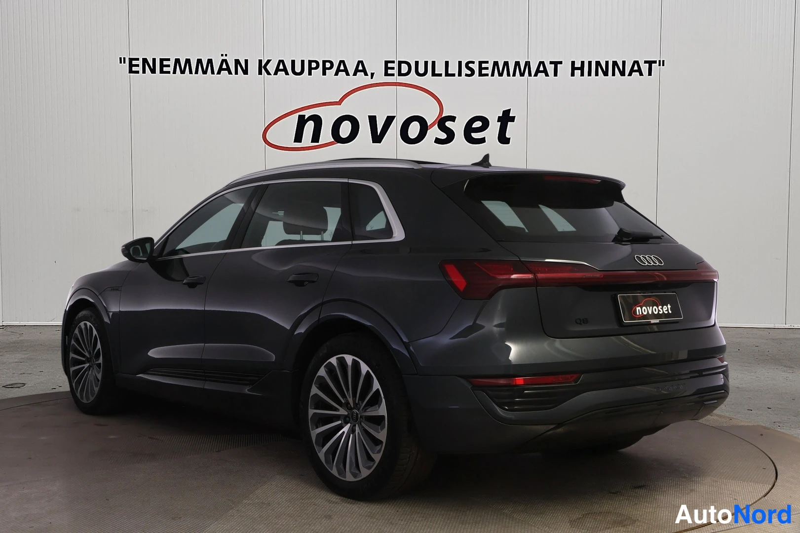 Takaviisto: Takakolmasosanäkymä tummansinisestä Audi Q8 e-tron -maasturista studiossa; peräluukku, poikittainen takavallolista ja vasen kylki näkyvät.