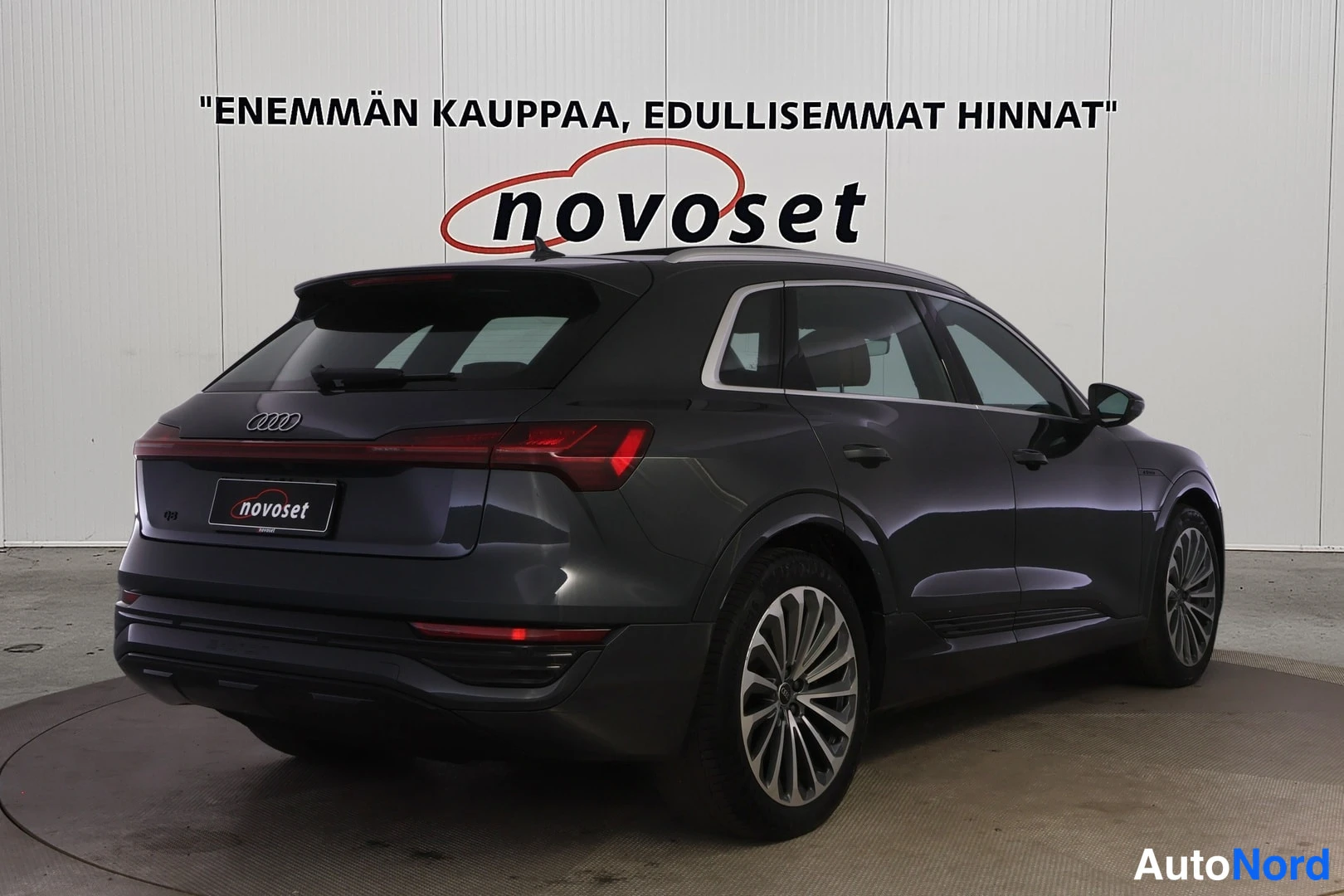 Takaviisto: Takakolmasosanäkymä tummansinisestä Audi Q8 e-tron -maasturista studiossa; peräluukku, takavalot ja oikea kylki näkyvät.