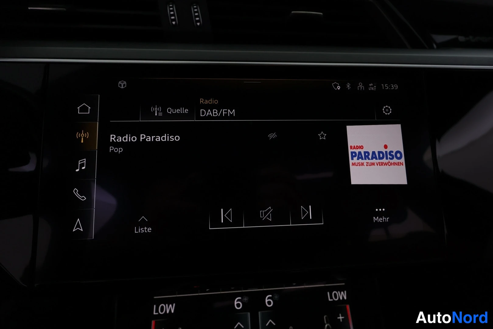 Muu: Autoon navigointiruutu, jossa on käynnissä radio Radio Paradiso, Pop, lähde DAB/FM, ja alareunassa ilmastoinnin näppäimet.