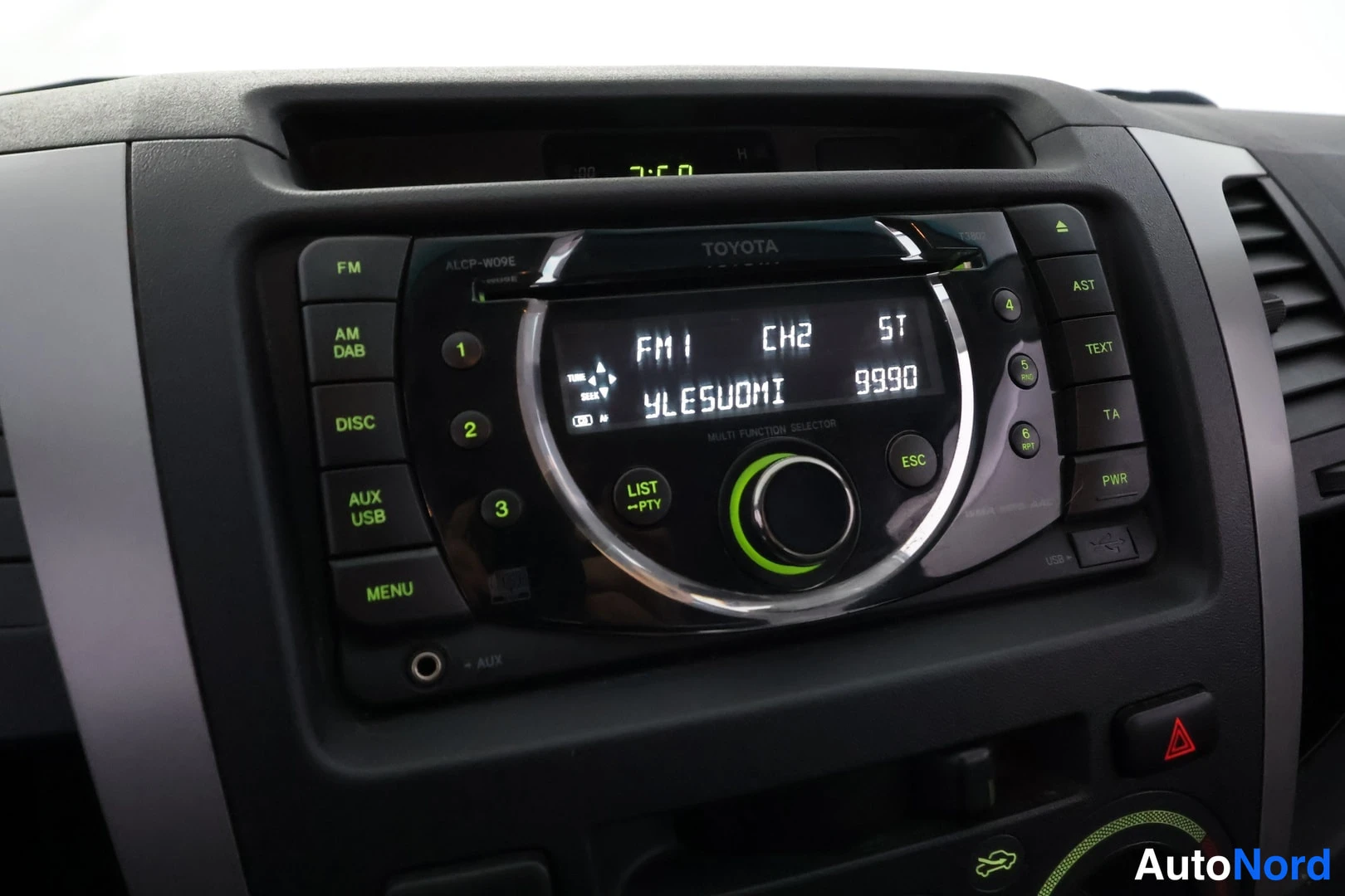 Muu: Kojelaudan radiokonsoli, näytöllä FM1 CH2 ST YLESUOMI 9990, painikkeet FM, AM/DAB, DISC, AUX/USB, MENU.