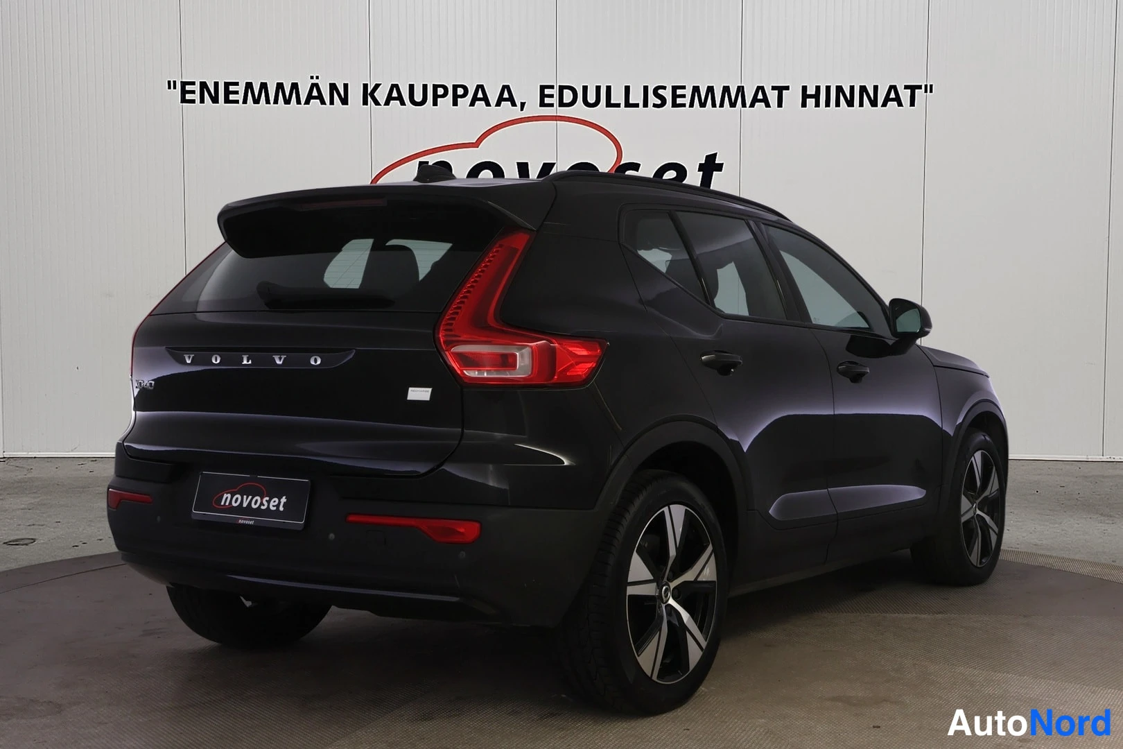 Takaviisto: Mustan Volvo XC40:n takaviistokuva toiselta sivulta, jossa näkyvät takavalot, takaluukun VOLVO-merkintä ja auton kylki.