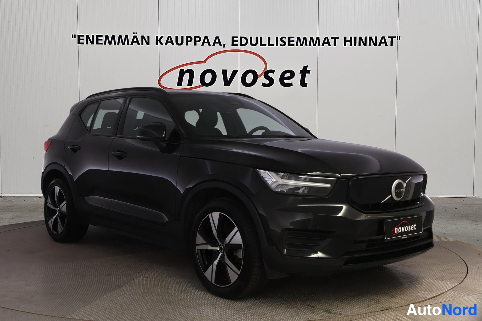 Etuviisto, nokka vasemmalle: Matkustusauton musta ulkovuosi valoisassa sisätiloissa, jossa näkyvät etupaneeli, ovet ja pyörät. Laitteet: LED-ajovalot, avainvapauslähtö ja alumiiniv