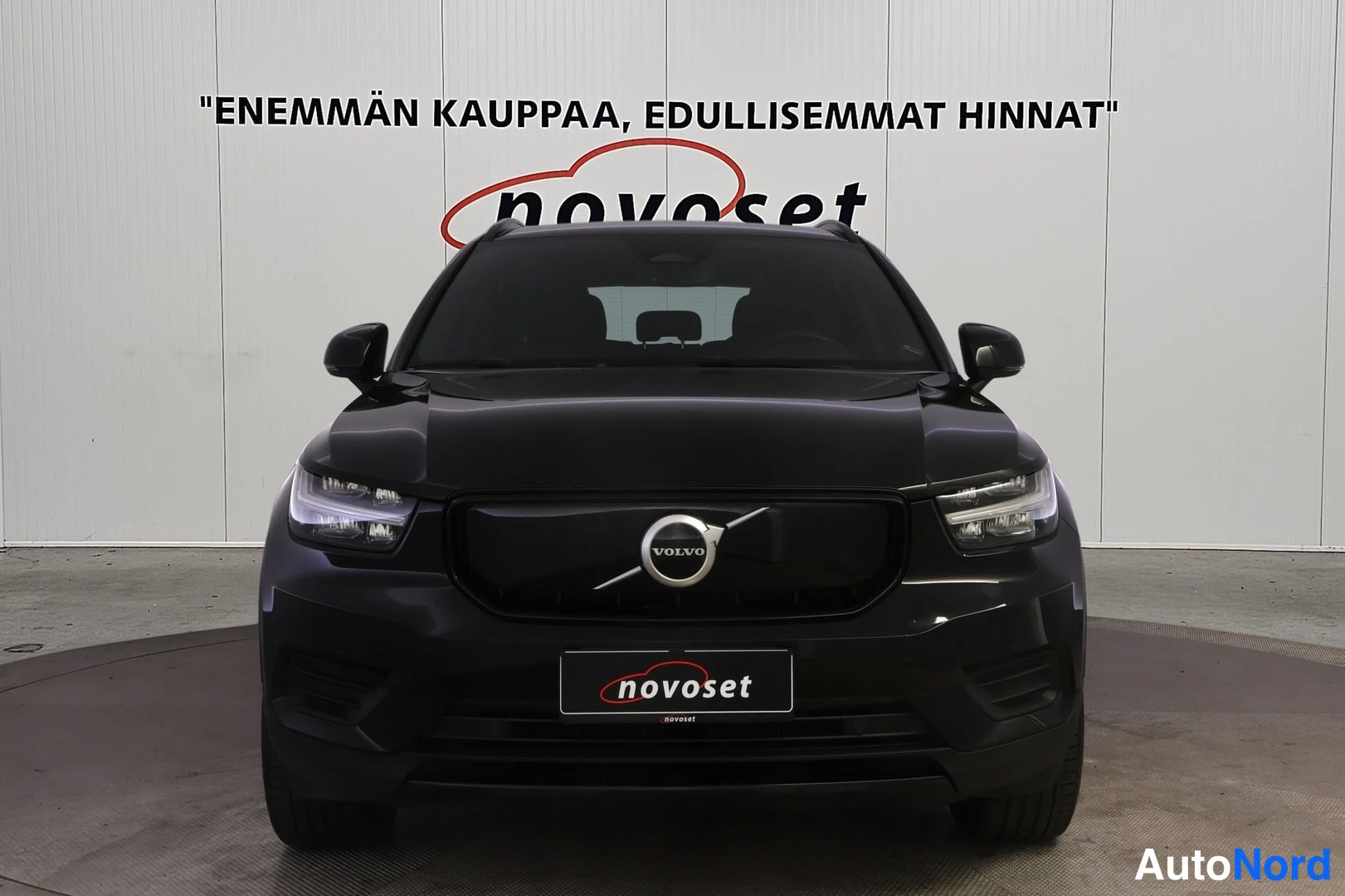 Edestä: Valokuva auton edestä (suoraan etupäästä). Volvo-logo on grillissä. LED-ajovalot ovat kytkettynä.