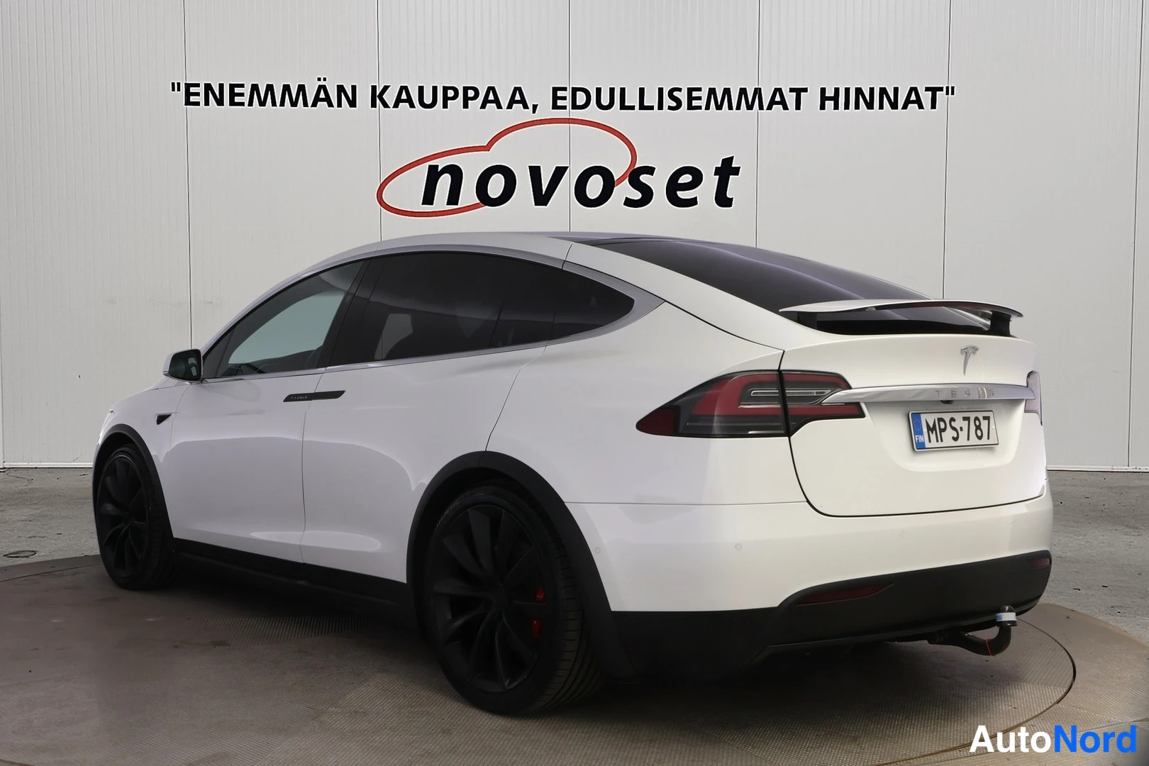 Takaviisto: Tesla Model X:n takaosa oikealta takaa, valkoinen kori, tummat ikkunat ja mustat aluvanteet.