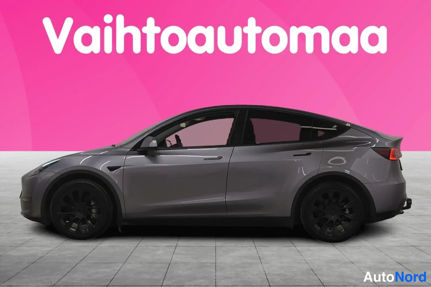 Sivulta: Tesla Model Y -henkilöauto harmaana sivukulmasta vasen kylki näkyvissä.