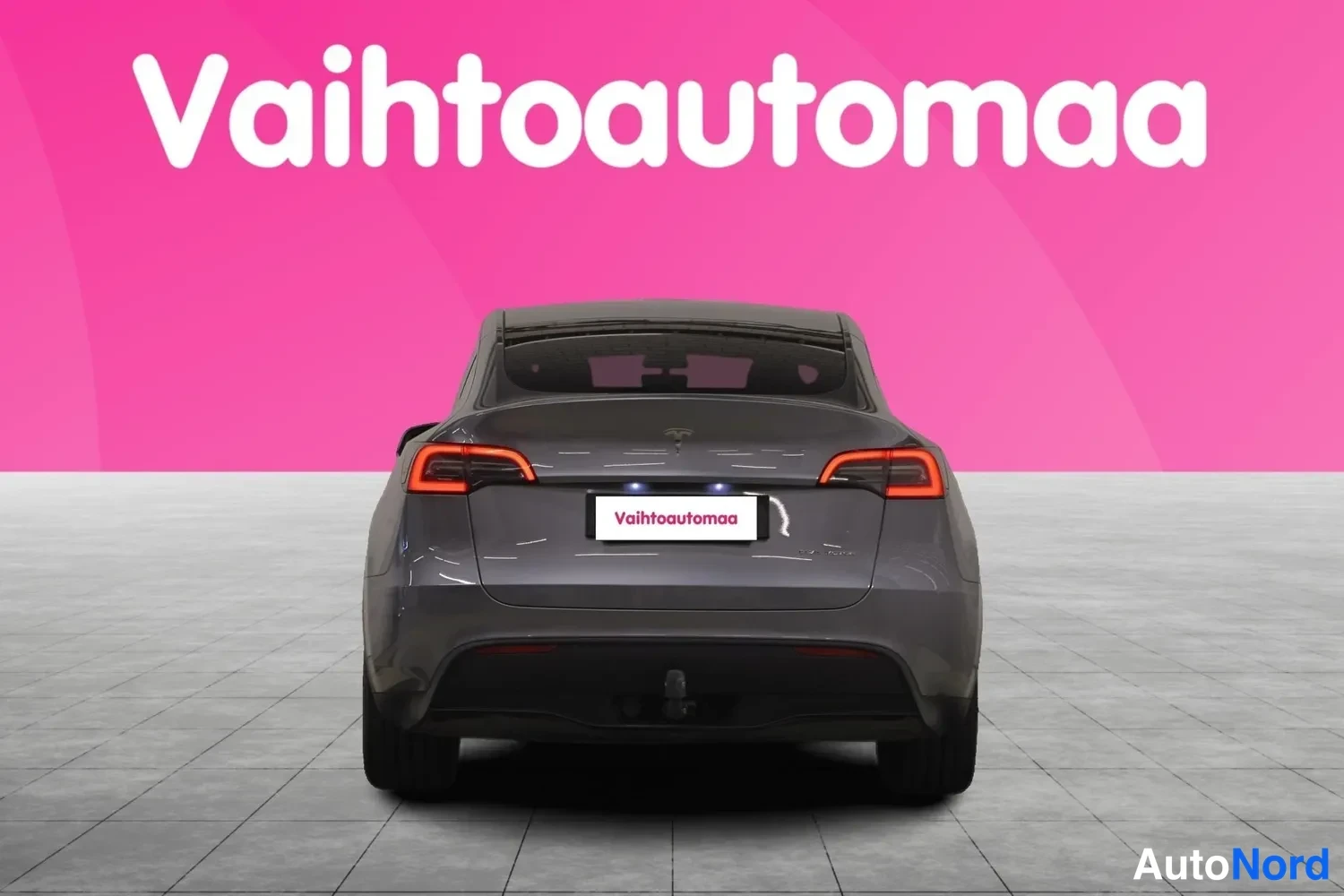Takaa: Tesla Model Y -henkilöauto harmaana suoraan takaa nähtynä.