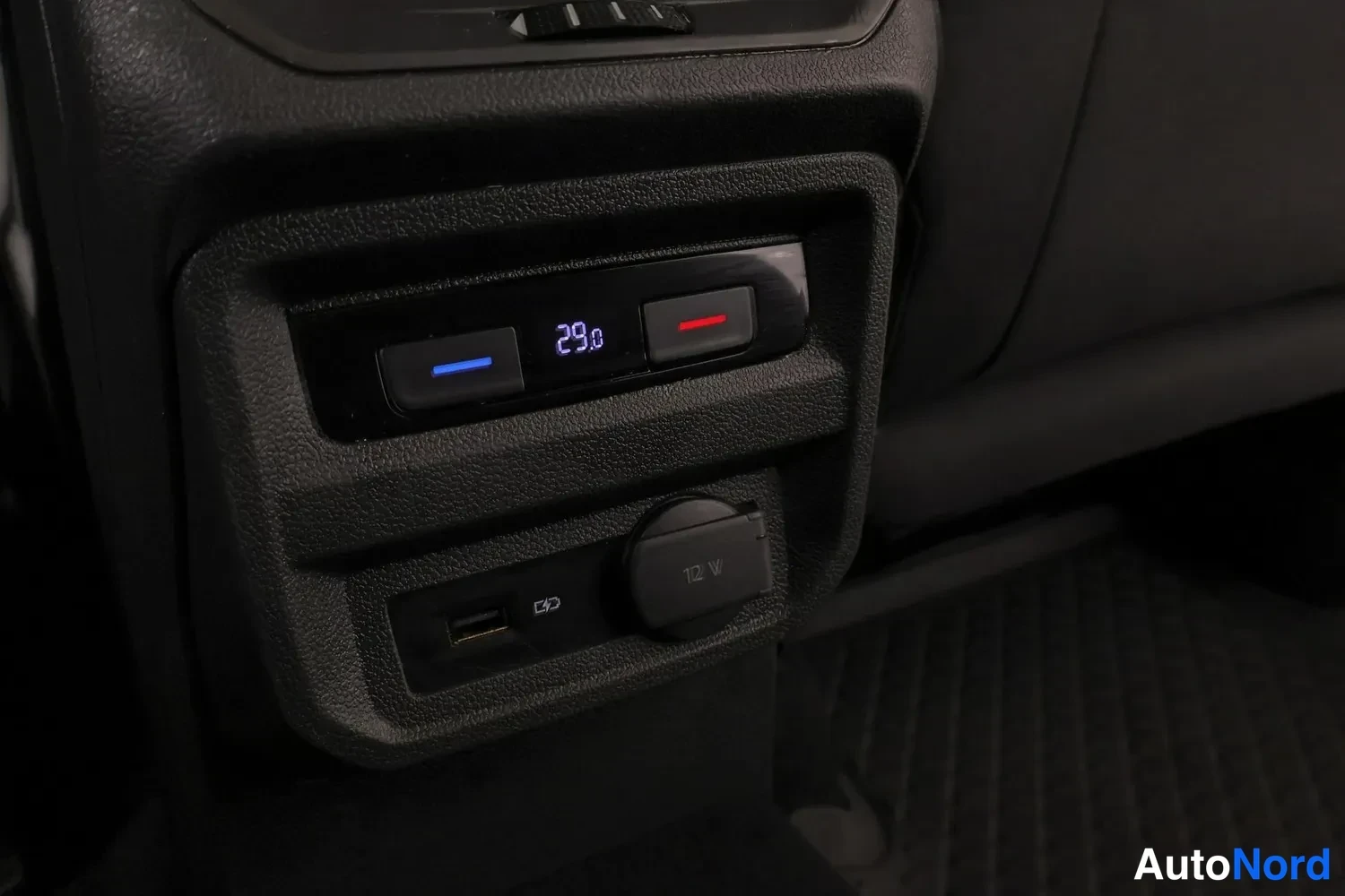 Muu: Takaistuimen takana oleva paneeli, jossa näkyvät lämmitysnäyttö 29.0, USB-liitin ja 12 V pistorasia