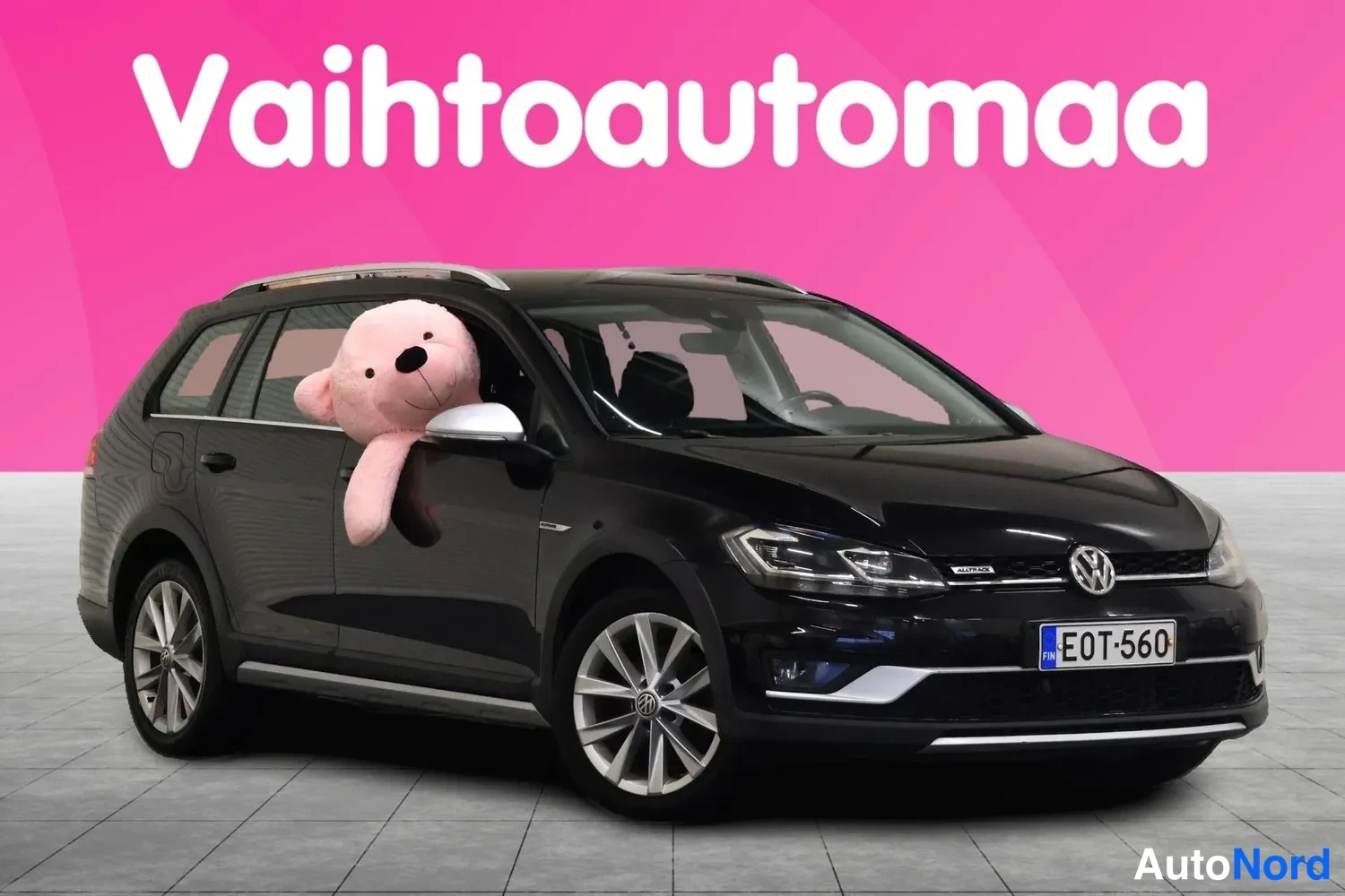 Etuviisto, nokka oikealle: Musta Volkswagen Golf Variant etuviistosta oikealta, rekisteritunnus, hopeiset vanteet ja kattokaiteet.