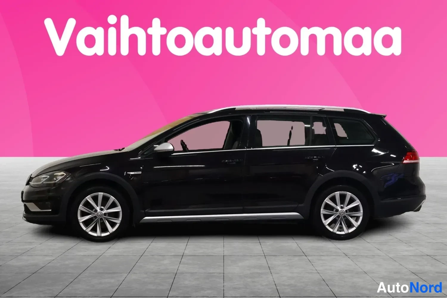 Etuviisto, nokka vasemmalle: Mustan Volkswagen Golf Variantin etu-kulmanäkyvä sivuprofiili, kattokaiteet ja hopeavanteet