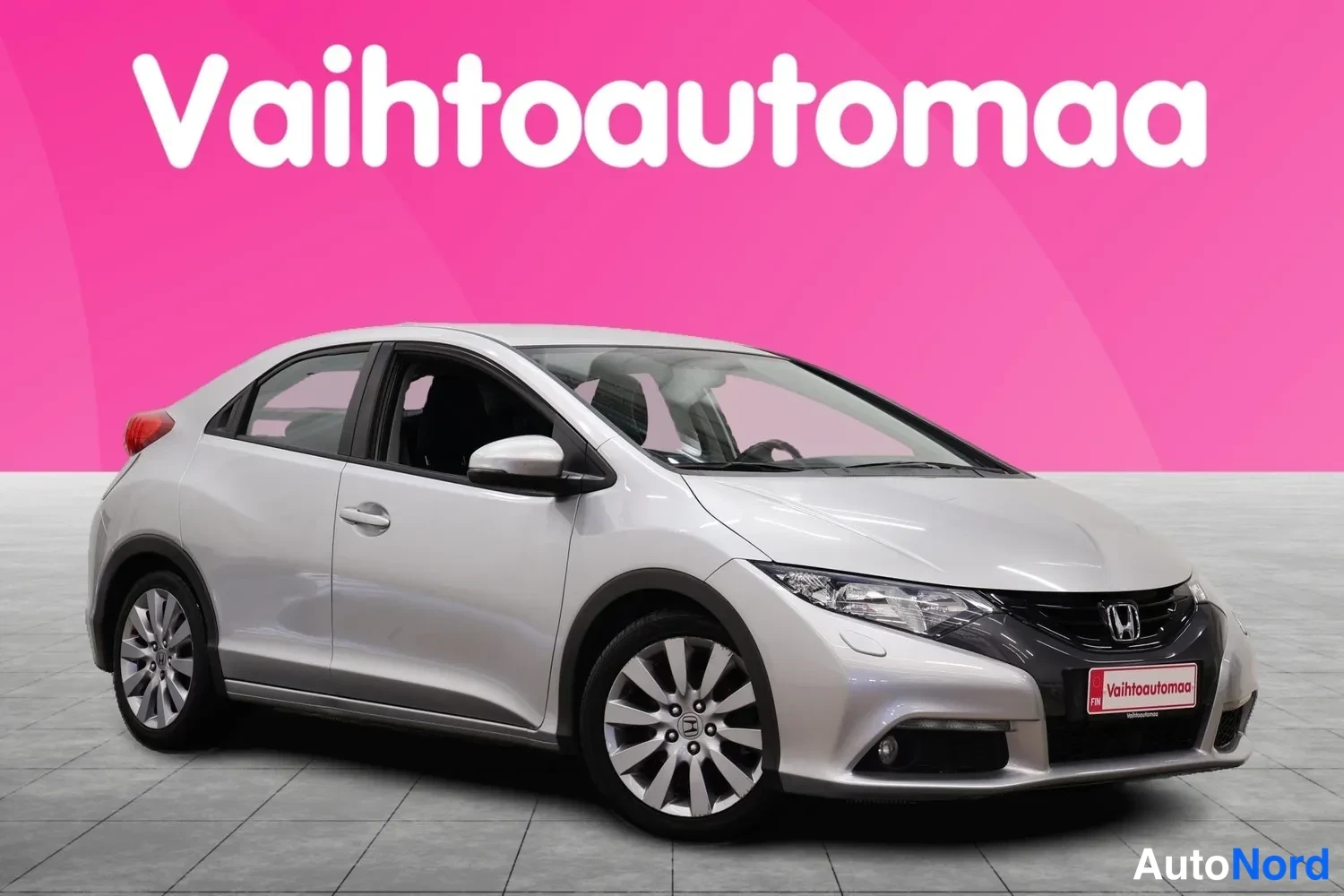 Etuviisto, nokka oikealle: Hopeanvärinen Honda-viistoperä etuviistosta oikealta, kylki ja keulamaski näkyvissä.