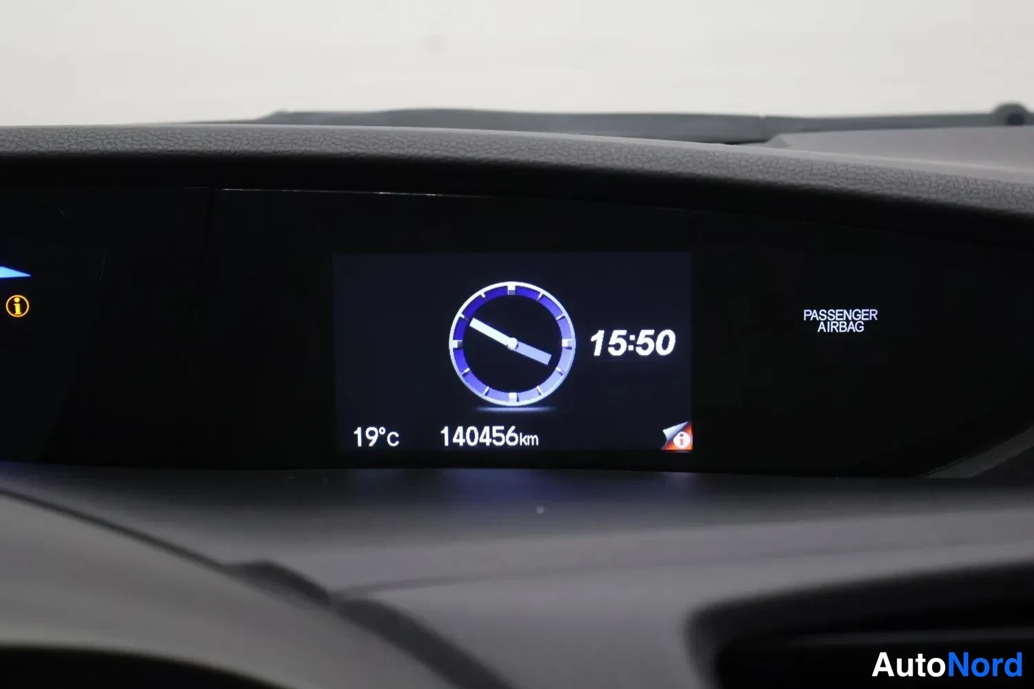 Muu: Auton kojelaudan näyttö näyttää kelloa 15:50, lämpötilan 19 °C ja matkamittarin lukeman 140456 km.