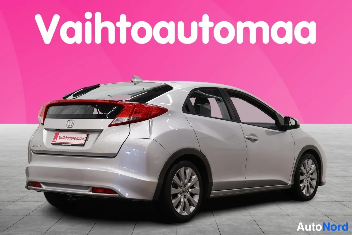 Takaviisto: Hopeanvärinen Honda Civic viistosti takaa vasemmalta nähtynä, takaosa ja vasen kylki kuvassa.
