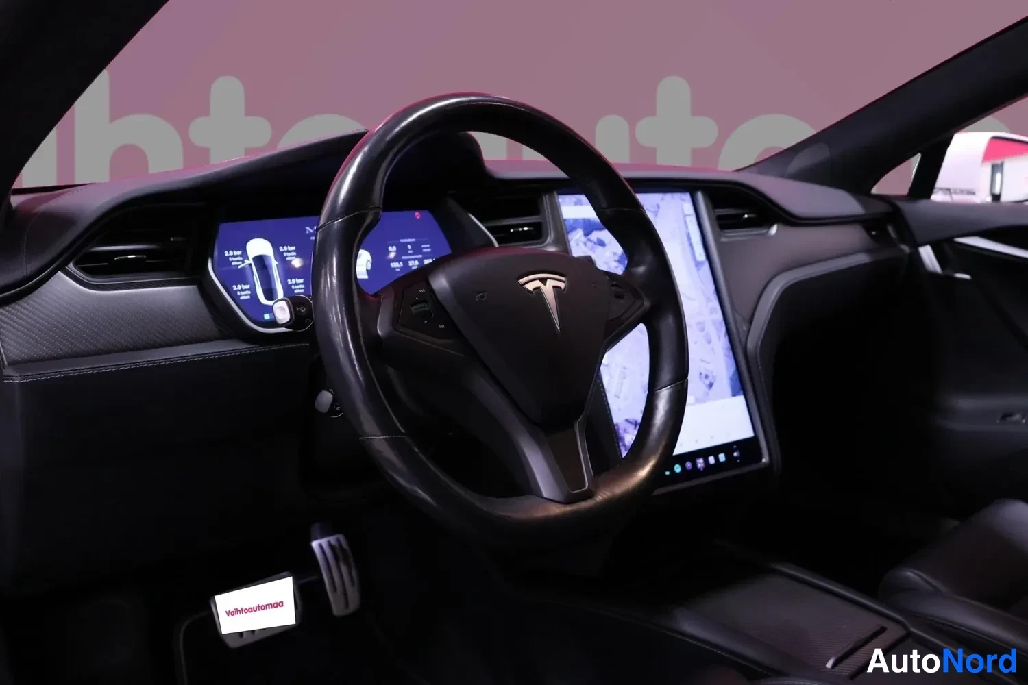Edestä: Tesla-ohjauspyörä, digitaalinen mittaristo ja suuri kosketusnäyttö keskikonsolissa.