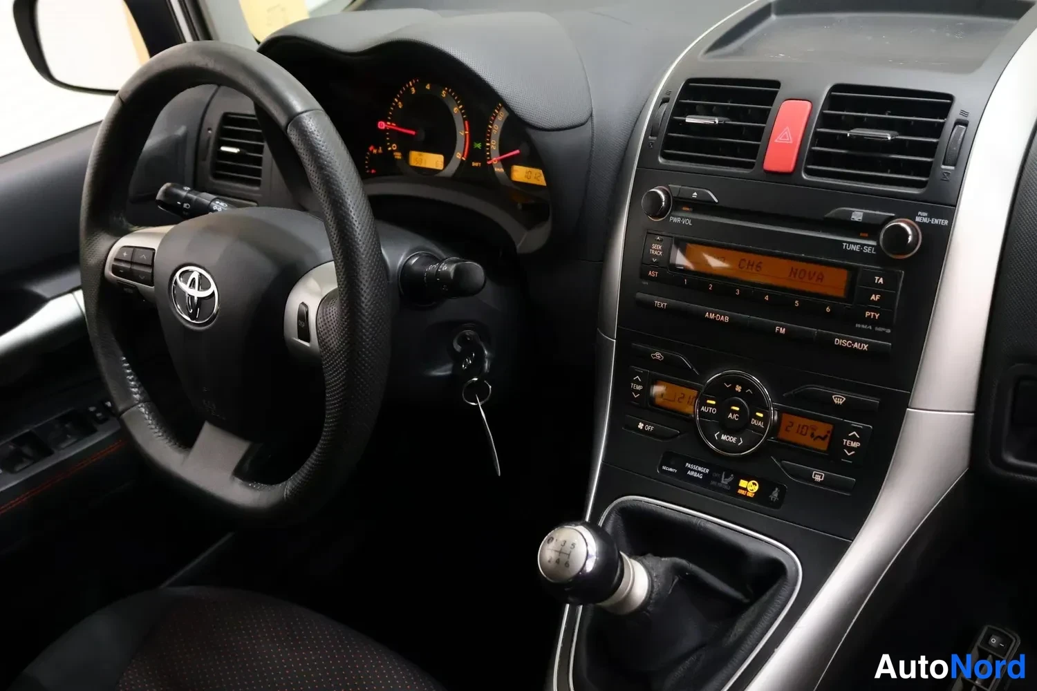 Muu: Ohjaamon kojelauta ja keskitaso: Toyota-ohjauspyörä, radiopaneeli (näytössä 'CHE MOVA'), automaattinen ilmastointi (A/C AUTO 21.0) ja käsivaihtaja.
