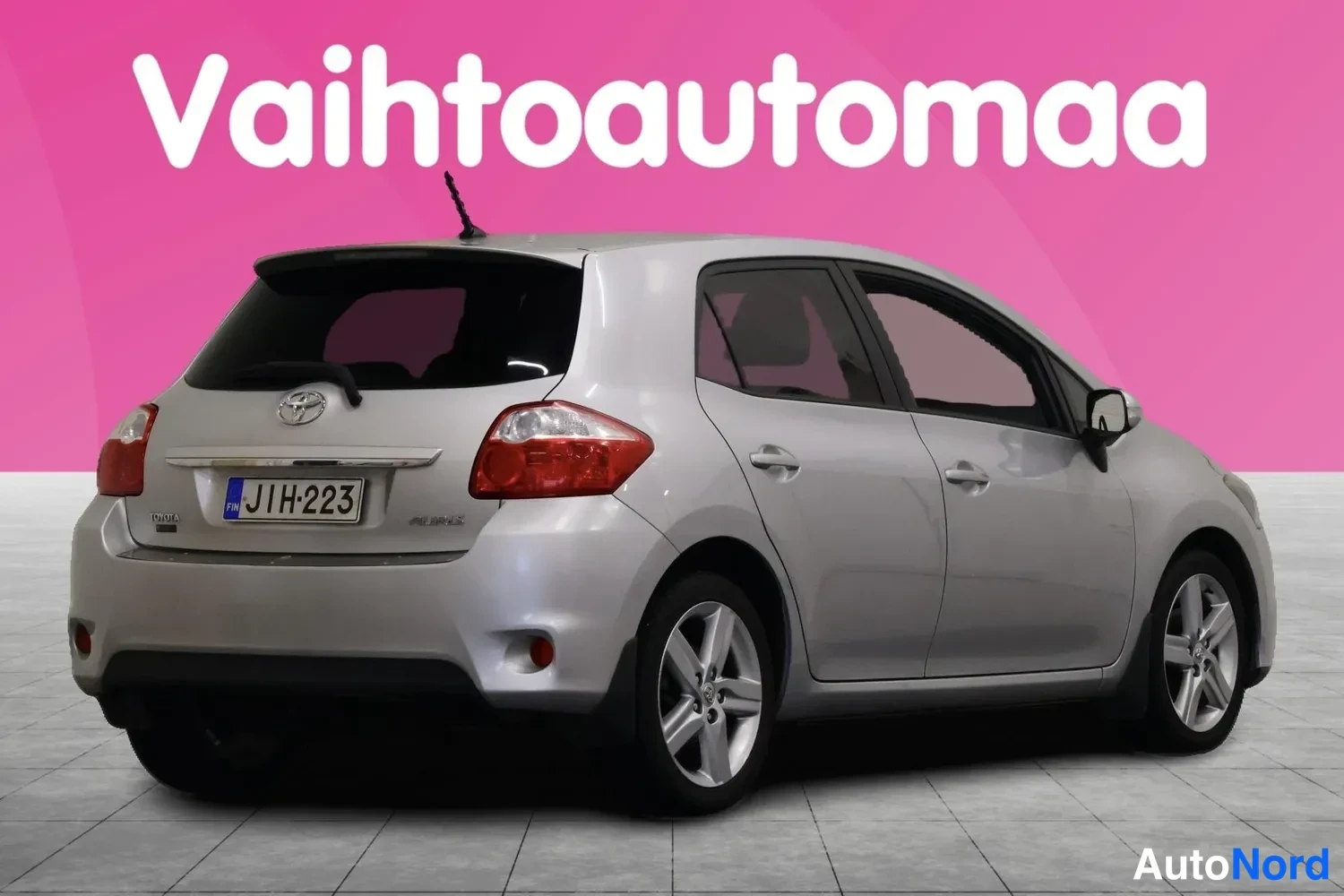 Takaviisto: Hopeanharmaa Toyota Auris -viistoperä takaa vasemmalta, rekisterikilpi ja viisikanta-vanteet näkyvissä.