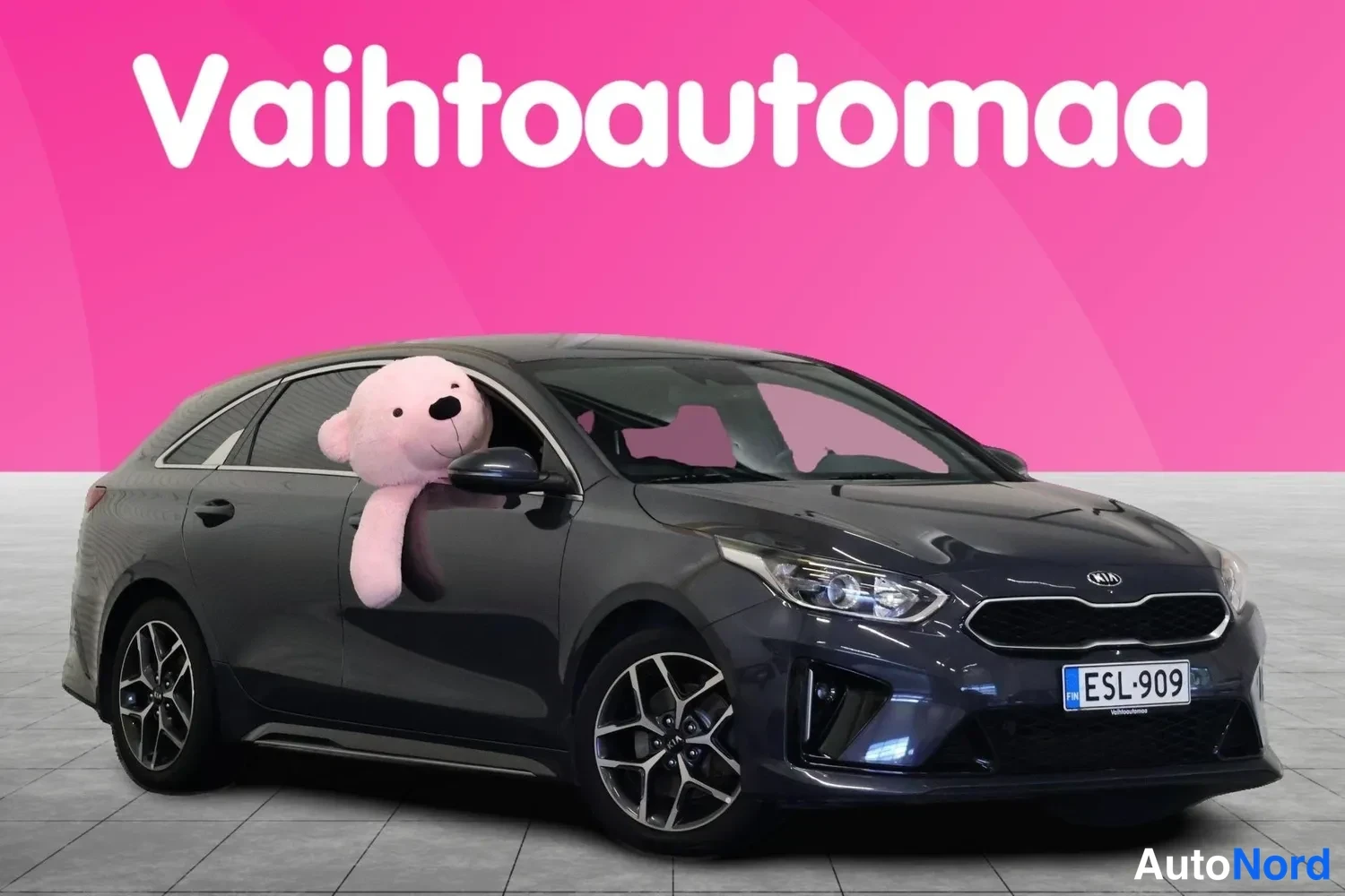 Etuviisto, nokka oikealle: Auto kolmannelta kulmalta kuvattuna, keula ja oikea kylki näkyvät, tummanharmaa koriväri, rekisteritunnus.