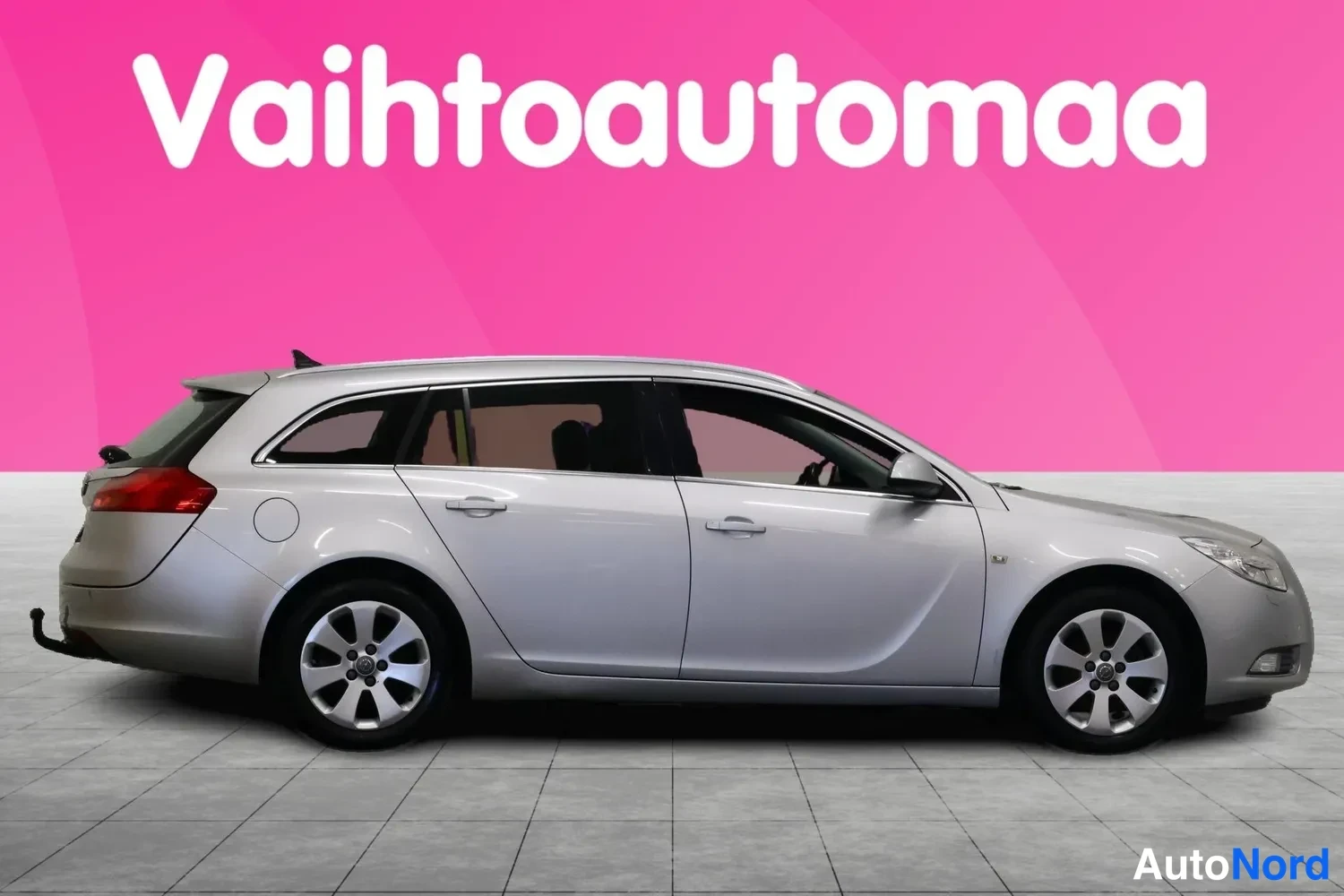 Takaviisto: Hopeanharmaa farmariauto sivusta-takakulmasta, perä kuvan vasemmassa reunassa.