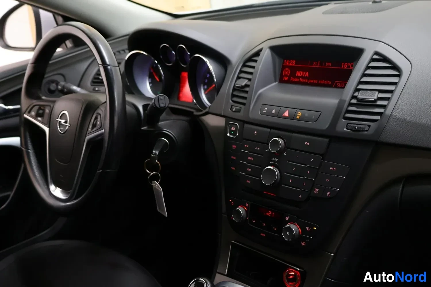 Etuviisto: Opel Insignian kojelauta ja ohjauspyörä vasemmalta katsottuna; radio ja avaimet lukko ovat näkyvissä.