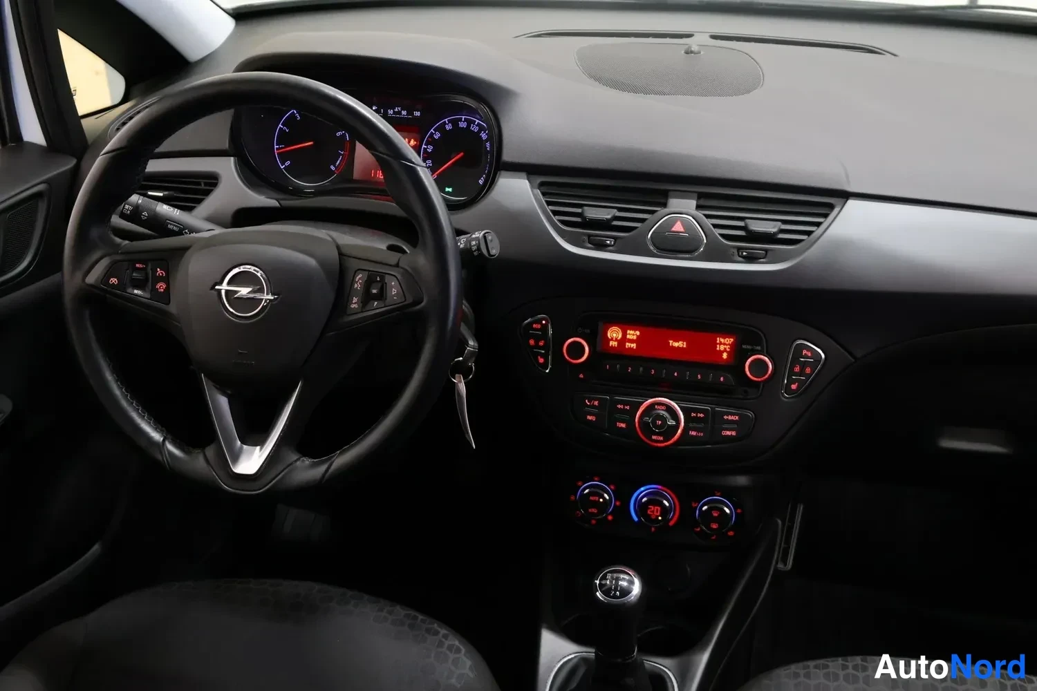Muu: Opel-merkkinen ohjauspyörä, analogiset mittarit, manuaalivaihteiston vaihdevipu ja keskiössä radiopaneeli punaisella näytöllä.