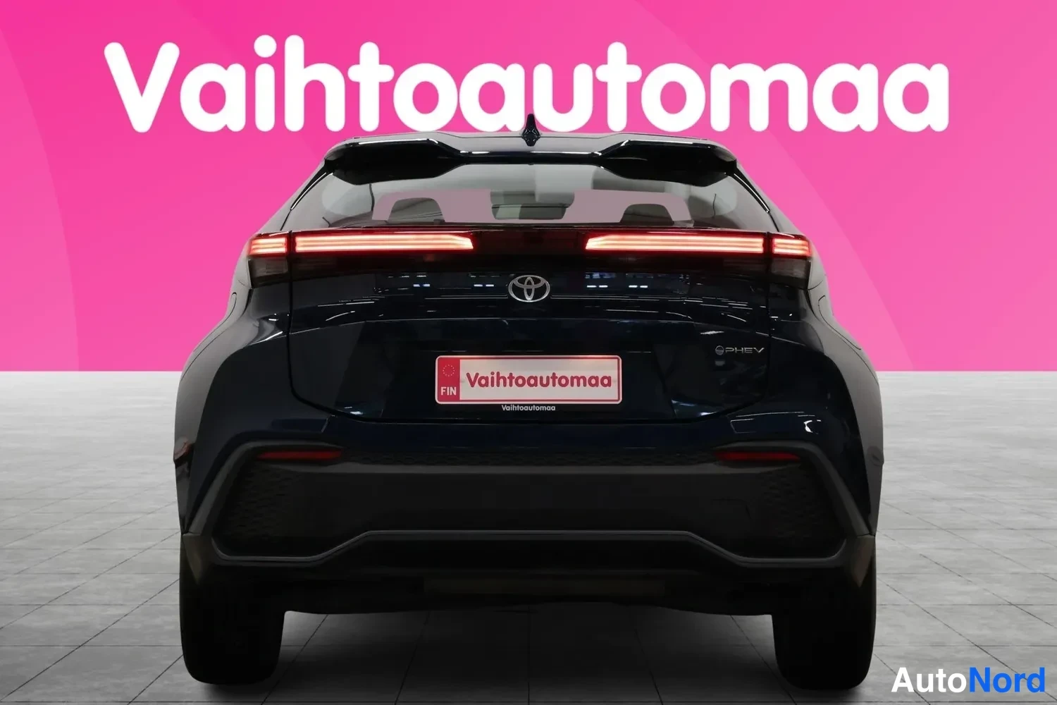 Takaa: Sininen Toyota C-HR suoraan takaa, kattospoileri ja yhtenäinen takavalo.