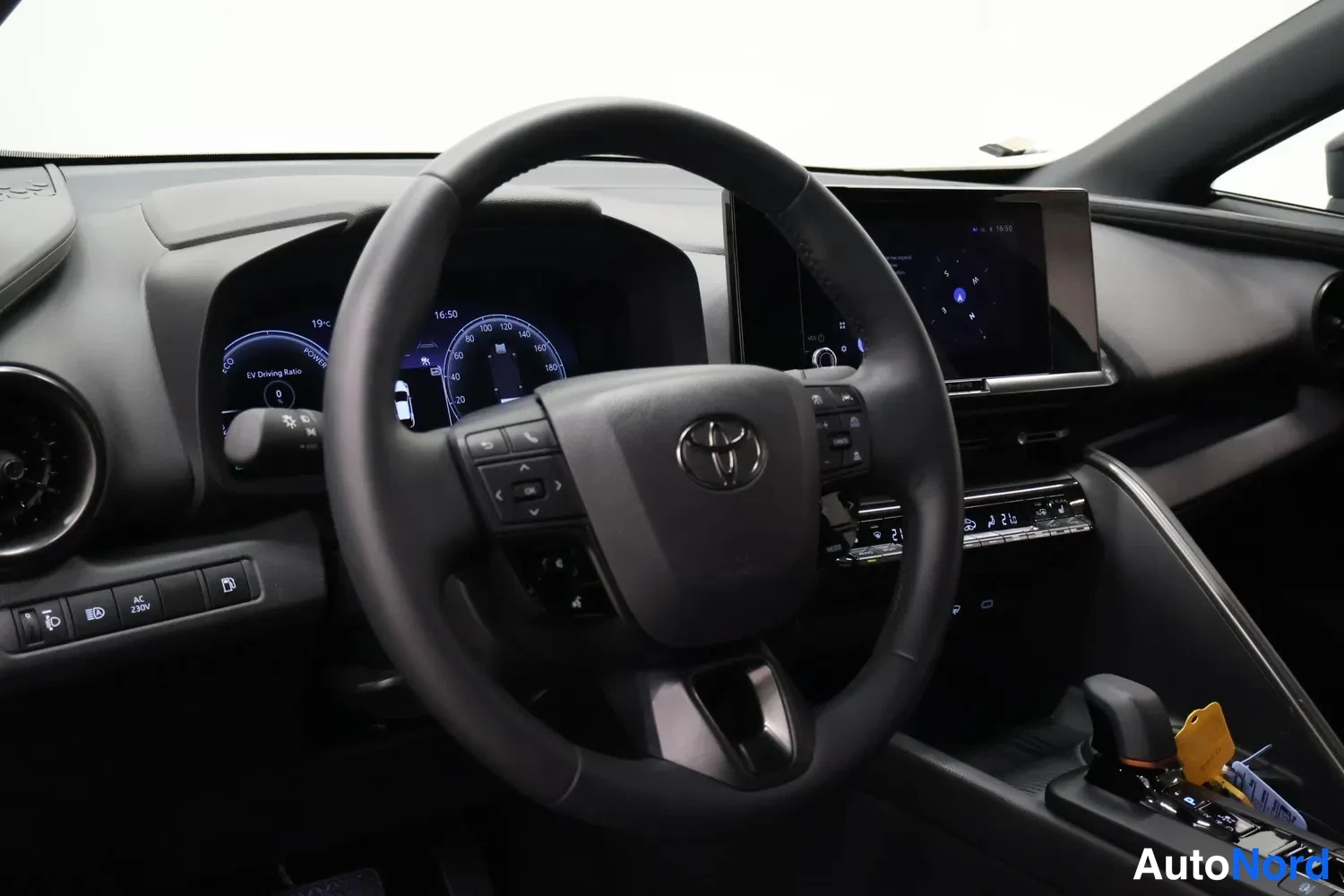 Muu: Kuljettajan näkymä ohjaamosta: Toyota-ohjauspyörä, digitaalinen mittaristo näytöllä jossa teksti 'EV Driving Ratio', kosketusnäyttö multimedialaitteessa ja vaih