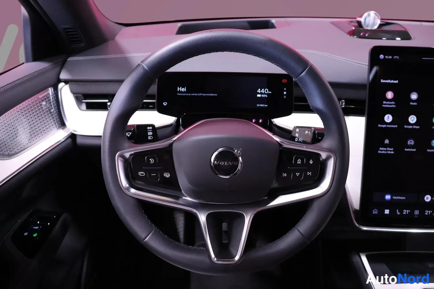 Muu: Volvo-ohjauspyörä lähikuvassa, taustalla digitaalinen mittaristonäyttö ja multimedianäyttö