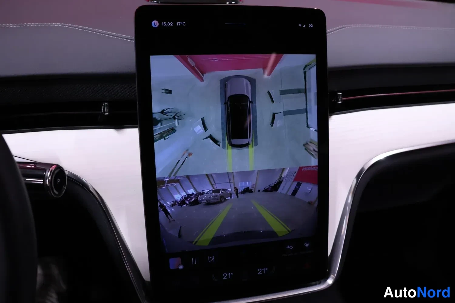 Sivulta: Auton infotainment-näyttö näyttää 360-kaappauskameran kuvan parkkihallista.