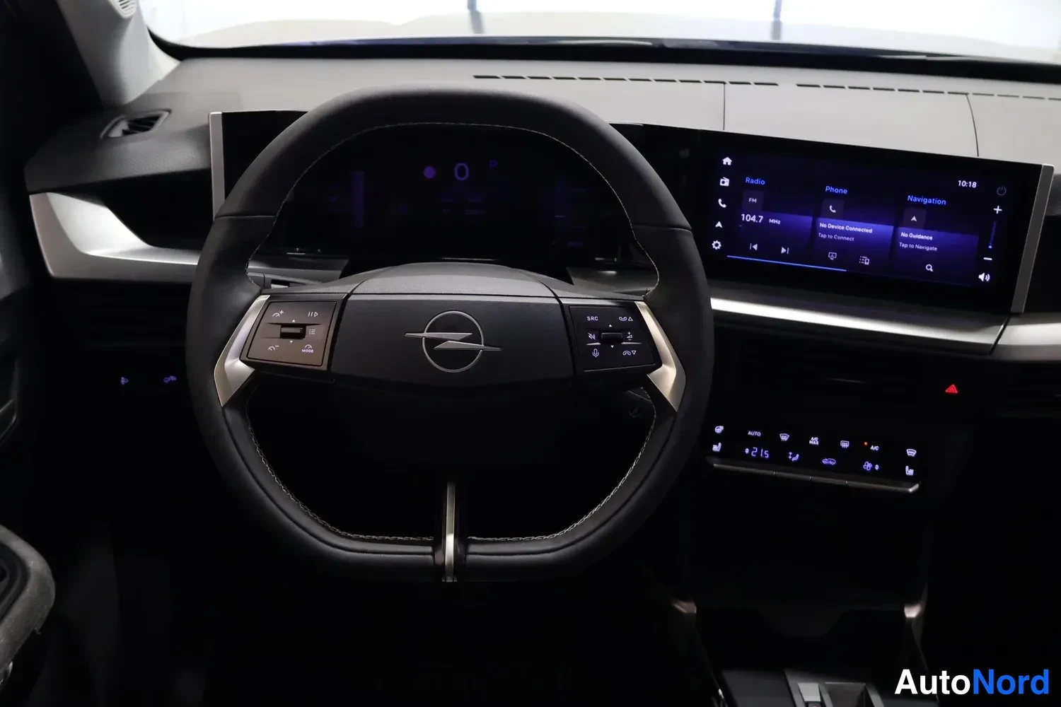 Ohjaamo: Opel dashboard with digital instrument cluster, steering wheel controls, and infotainment screen displaying navigation interface