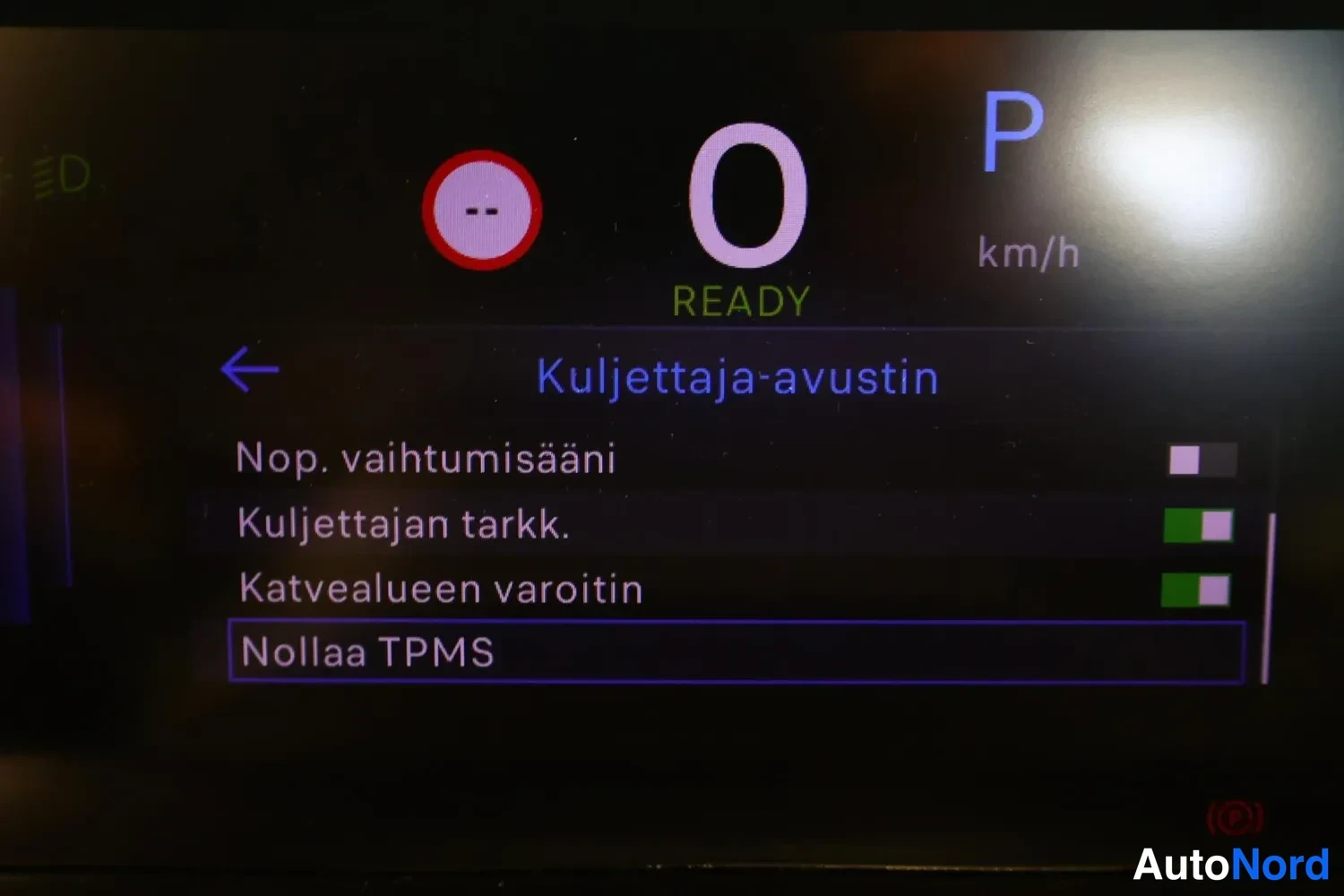 Muu: Kojelaudan näyttö, jossa on valittu Kuljettaja-avustin-valikko ja asetuksia kuten Katvealueen varoitin.