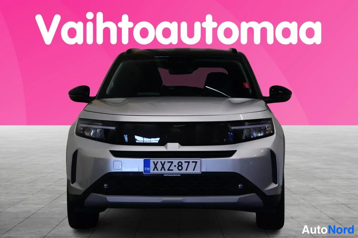 Edestä: Etukäyntikuva hopeanvärisestä Opel Frontera -tyylisestä SUV:sta, rekisteritunnus, taustalla Vaaihtoauto­maa-logo