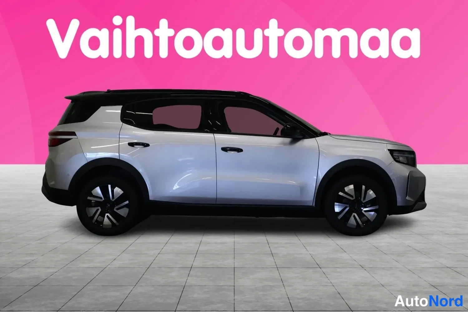 Sivulta: Silver Opel Frontera SUV side profile showing two-tone alloy wheels and dark-tinted windows against pink backdrop