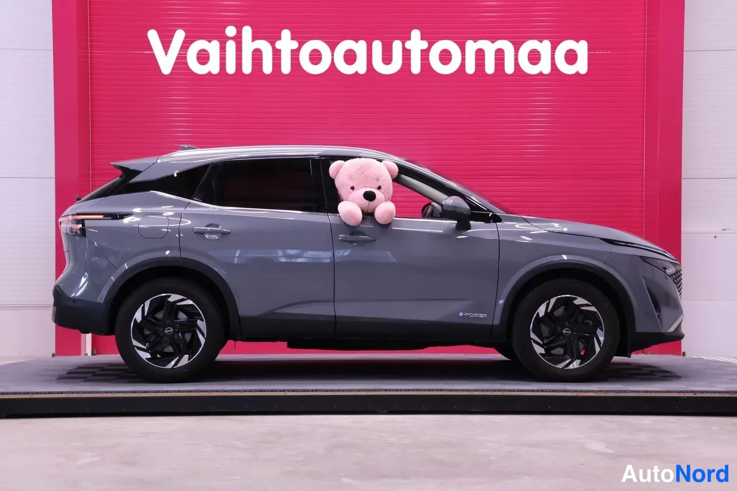 Sivulta: Nissan Qashqai sivuprofiilista vasemmalta, pinkki tausta.