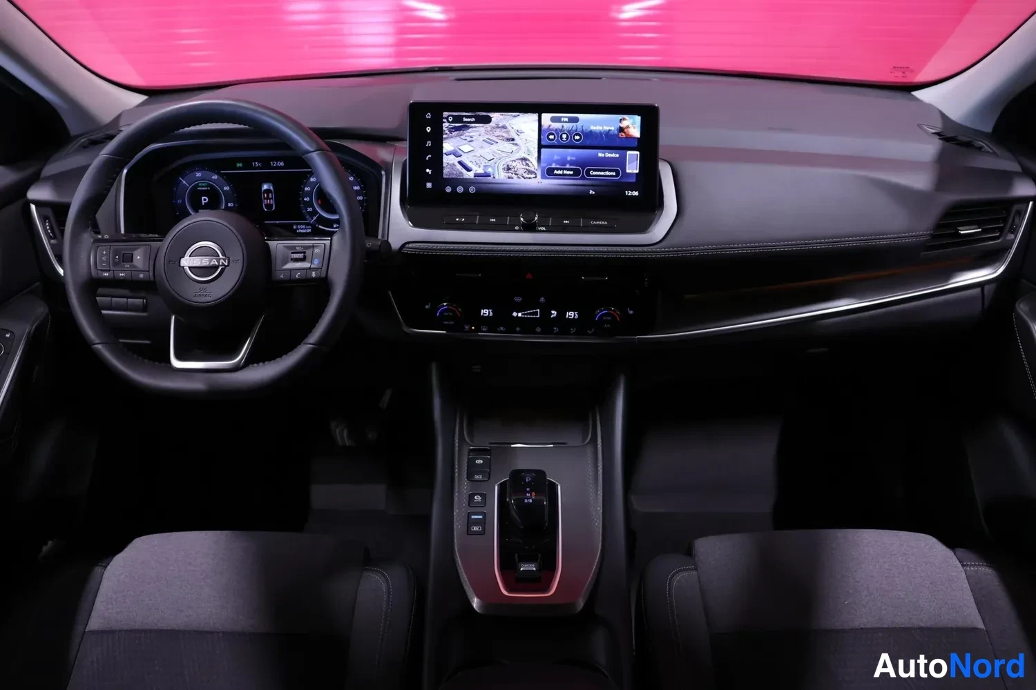 Edestä: Ohjaamo edestä: Nissan-ohjauspyörä, digitaalinen mittaristo, karttanäkymää näyttävä kosketusnäyttö, automaattivaihteen valitsin keskikonsolissa ja kaksipiirtein