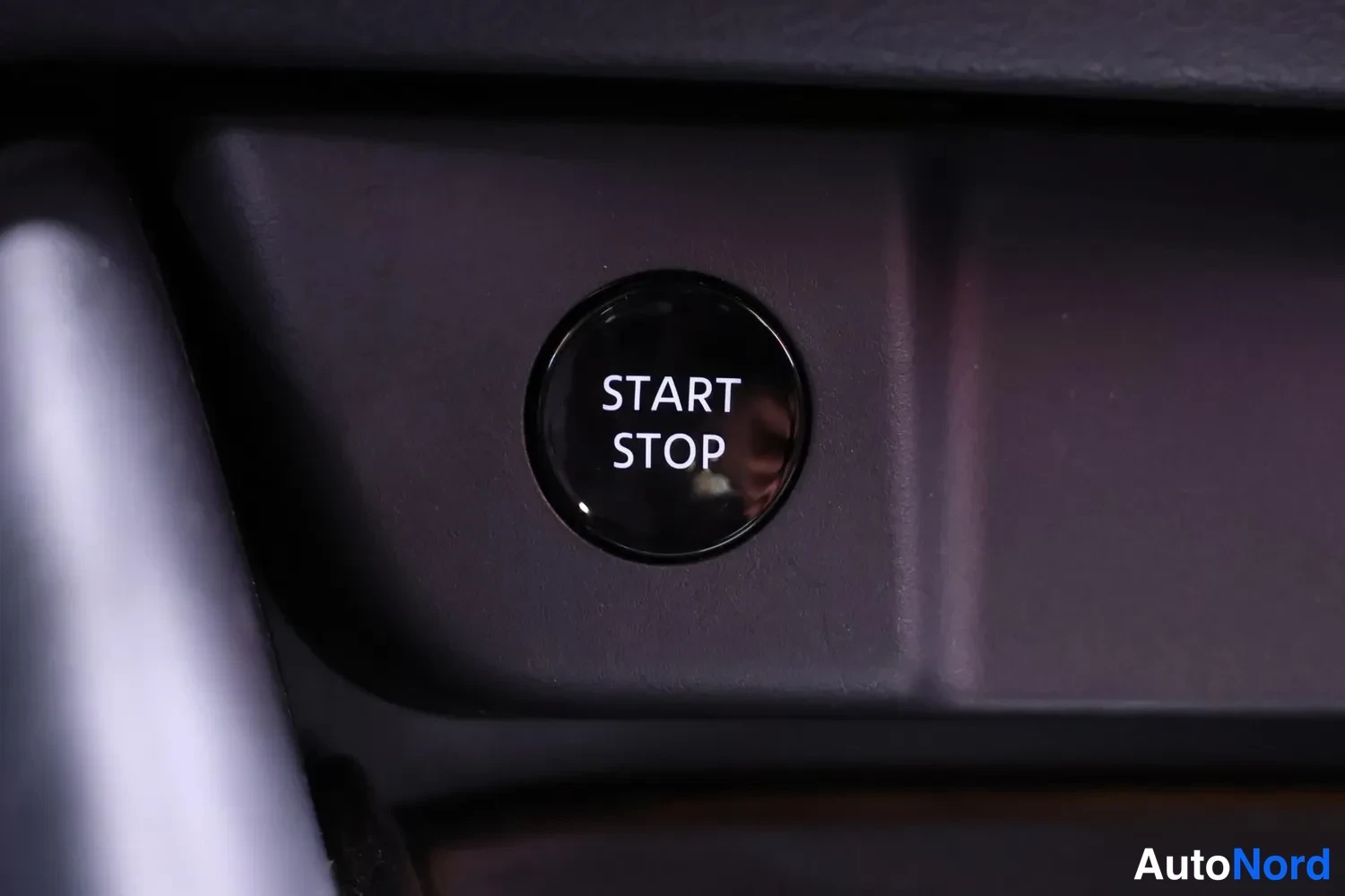 Yksityiskohta: Ohjaamon START STOP -käynnistyspainike lähikuvassa